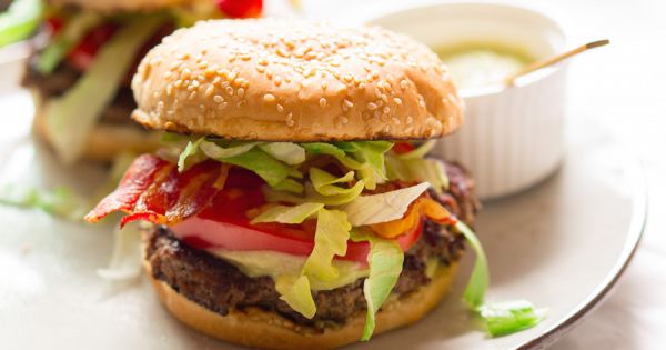 Foto van een smash burger met bacon, avocado en blauwe kaas