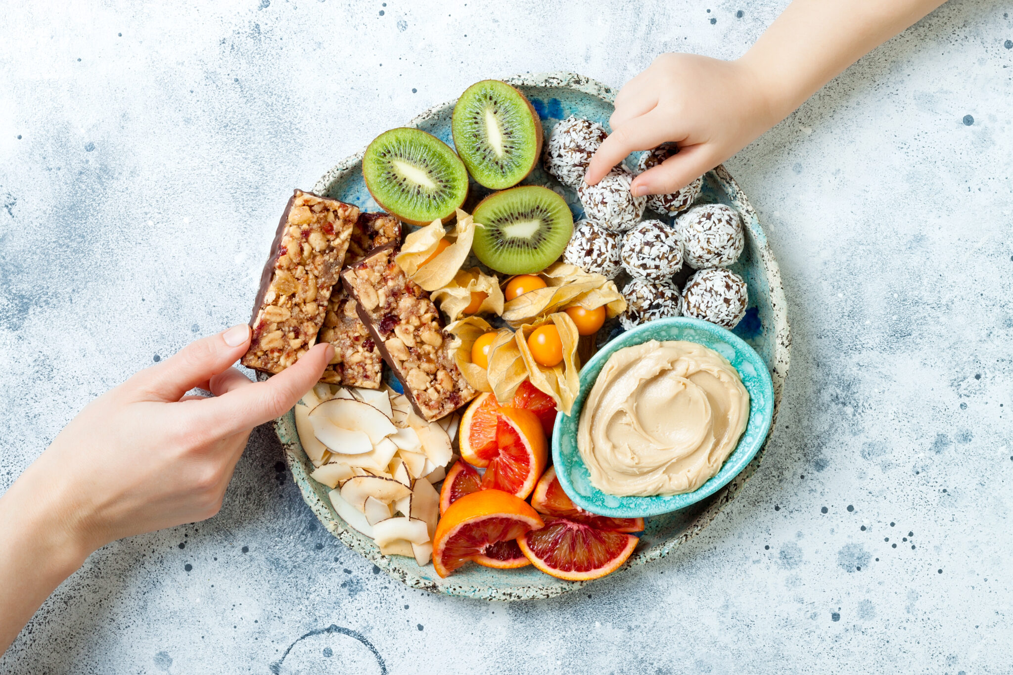 Mother sharing healthy vegan dessert snacks with toddler child.